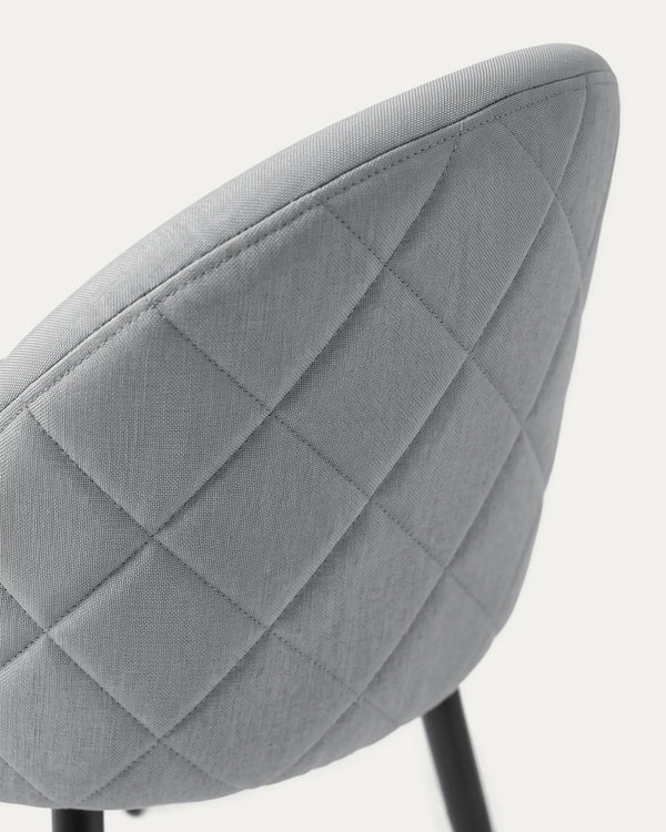 Detalle respaldo curvo tapizado poliéster gris silla Sora comedor patas metal negro Venhoouse Chile