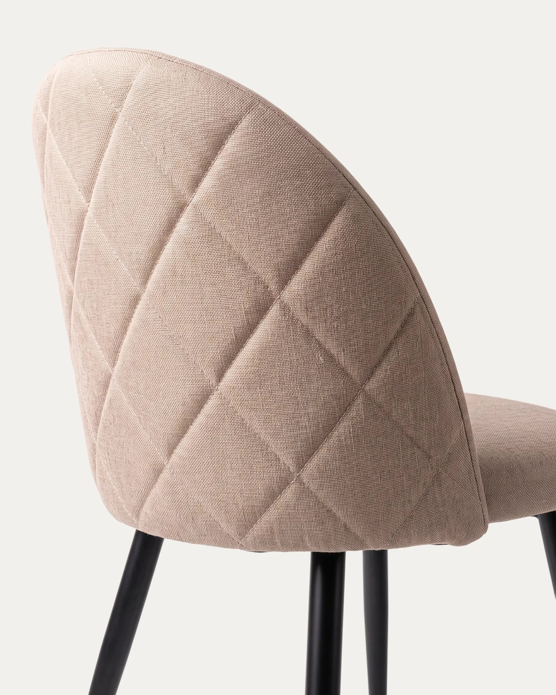 Detalle respaldo curvo tapizado poliéster taupe silla Sora comedor patas metal negro Venhoouse Chile